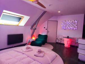 a purple room with a bed and a tv at Domaine de la Besnerie Gites avec SPA Privatif à 10 min du Mont St Michel in Tanis +48 photos
