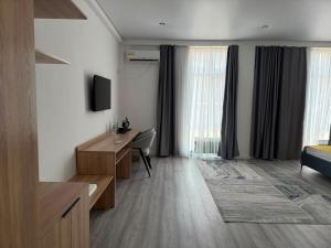 a living room with a desk and a bedroom at TUMAR hotel in Zhezdi