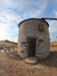 a stone building with a door in a field at Penacova Moinho do Ligeiro near Coimbra in Penacova