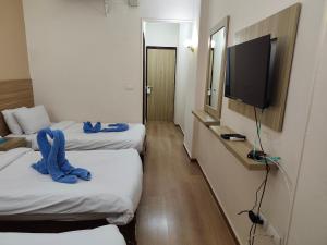 a hotel room with two beds and a flat screen tv at S S Luxor Hotel in Luxor