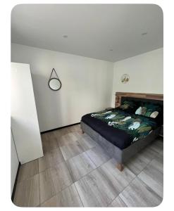 a bedroom with a bed and a white wall at Chez Melanie in Neuilly-le-Réal