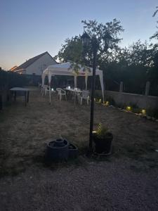 a street light in a yard with a tent and a table at Chez Melanie in Neuilly-le-Réal