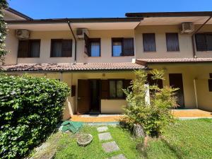 a house with a green yard in front of it at Villa Dosso Fiorito in Lignano Sabbiadoro