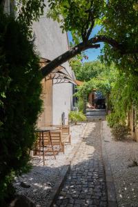 a table and bench on a stone path in front of a building at La parenthèse Provençale in Viry-Châtillon