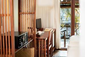 a living room with a desk with a tv and a couch at My Dream Boutique Resort in Luang Prabang