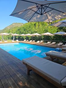 a swimming pool with tables and umbrellas at Lugina e Shengjergjit ,Bujtinat in Tirana