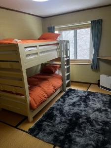 a bedroom with two bunk beds and a window at Corduroy Ski Lodge Madarao Tangram in Shinano +12 photos