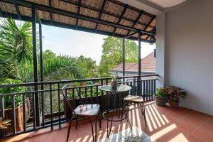 a balcony with a table and chairs and a view at The Sears Residence Siem Reap in Phumĭ Réach Born (2)
