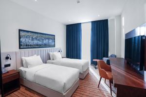 a hotel room with two beds and a desk at Jizzax Hotel Tashkent in Tashkent +42 photos