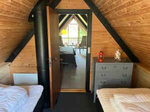 a attic room with two beds and a mirror at Authentic wooden summer house in Øster Hurup