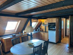 a kitchen with a table and chairs in a room at Authentic wooden summer house in Øster Hurup