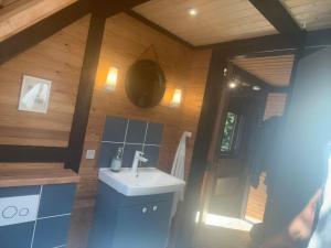 a bathroom with a sink and a shower in a cabin at Authentic wooden summer house in Øster Hurup +20 photos