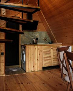 a kitchen in a log cabin with a washer at Machakhela Peaks in Sindietʼi