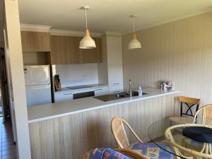 a kitchen with a sink and a table and chairs at Edna's Retreat in Tathra +6 photos