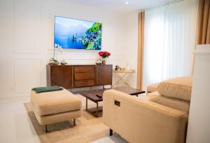 a living room with a couch and a tv on a wall at La parenthèse Provençale in Viry-Châtillon