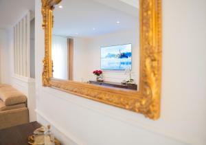 an ornate gold mirror on a wall in a living room at La parenthèse Provençale in Viry-Châtillon