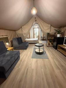 a room with a tent with a couch and a table at Glamping Lake Escape in Virpazar
