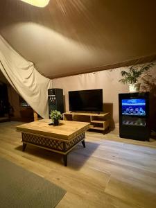 a living room with a table and a tv at Glamping Lake Escape in Virpazar