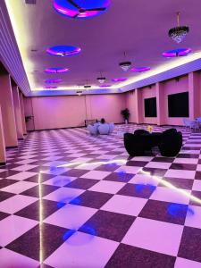 a large room with a checkered floor and purple lighting at Horizon Resort Pushkar-Feel of The Nature in Pushkar