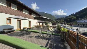 a patio with tables and chairs and umbrellas at Casteluce Hotel Funivie in Pinzolo