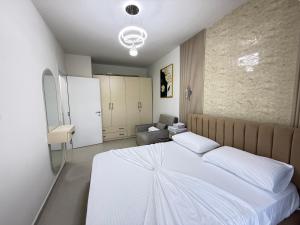a bedroom with a white bed and a couch at Shengjin Apartament 5 M in Shëngjin