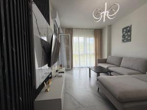 a living room with a couch and a flat screen tv at Shengjin Apartament 5 M in Shëngjin