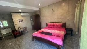 a bedroom with a pink bed in a room at Bankrut Backpack in Sathani Ban Krut