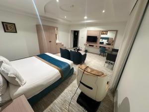 a hotel room with a large bed and a desk at فندق روز أوسيس - Roz Oasis Hotel in Najran