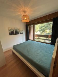 a bedroom with a bed and a large window at Ovronnaz , 2 pièces appartement Marana in Ovronnaz