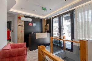 an office with a red chair and a window at F&J Hotel in Sarandë