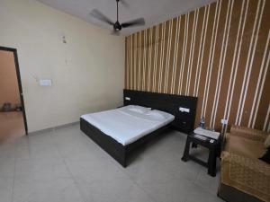 a small bedroom with a bed and a table at Hotel MNP in Jabalpur +5 photos
