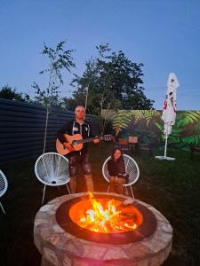 a man playing a guitar next to a fire pit at Sofia Armony in Iezureni