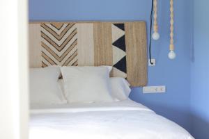 a bed with a head board with white pillows at Can Alemany in Santa Margarita de Mombúy