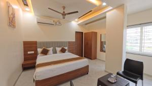 a bedroom with a bed and a ceiling fan at Hotel Otel Besa in Nagpur