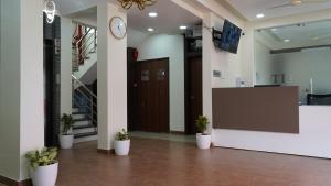 an office lobby with a reception desk and potted plants at Hotel Otel Besa in Nagpur