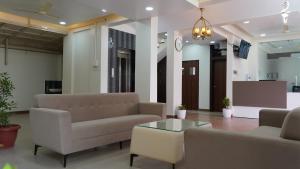 a lobby with couches and a coffee table in a building at Hotel Otel Besa in Nagpur