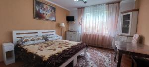 a bedroom with a bed and a table and a window at Вікенд WeekEnd in Kvasy