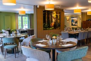 a restaurant with tables and chairs and a painting on the wall at La Barrière de Transinne in Libin