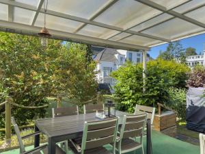 a wooden table and chairs under a pergola at Objekt-Nr 237 - Priwall - Mecklenburger Landstraße in Priwall