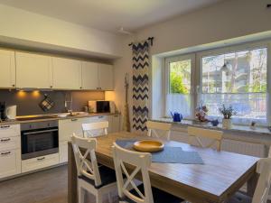 a kitchen with a wooden table and white cabinets at Objekt-Nr 237 - Priwall - Mecklenburger Landstraße in Priwall