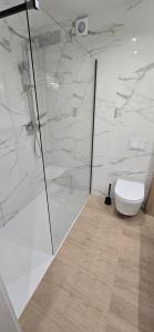 a bathroom with a toilet and a glass shower at White Pearls Apartaments Dąbki in Dąbki +18 photos