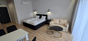 a room with a bed and a couch and a chair at White Pearls Apartaments Dąbki in Dąbki