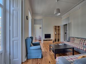 ein Wohnzimmer mit einem blauen Sofa und einem Tisch in der Unterkunft Almirante Reis Apartment in Lissabon