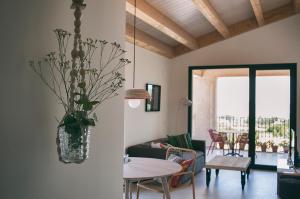 a living room with a table and a vase with flowers at Can Alemany in Santa Margarita de Mombúy