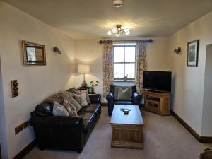 a living room with a couch and a tv at Heigh Farmhouse in Lancaster