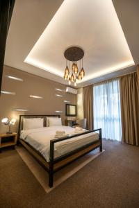 a large bedroom with a large bed and a chandelier at Hotel Sun Loznica in Loznica