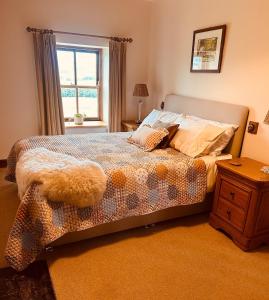 a bedroom with a large bed with a window at Heigh Farmhouse in Lancaster