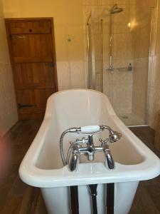 a white bath tub with a faucet in a bathroom at Heigh Farmhouse in Lancaster +9 photos