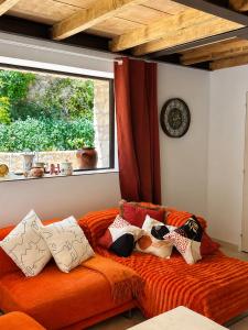 an orange couch in a living room with a window at Atelier Provençal in La Celle-sous-Gouzon