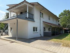 a white house with a balcony on top of it at Rent Room Vermietungen in Oberhausen
